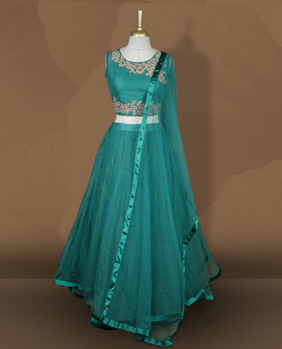 Teal green colour lehenga set with stitched sleeveless blouse featuring floral sequin embroidery on neckline and waist, paired with a matching shimmer layered flared lehenga and sheer dupatta