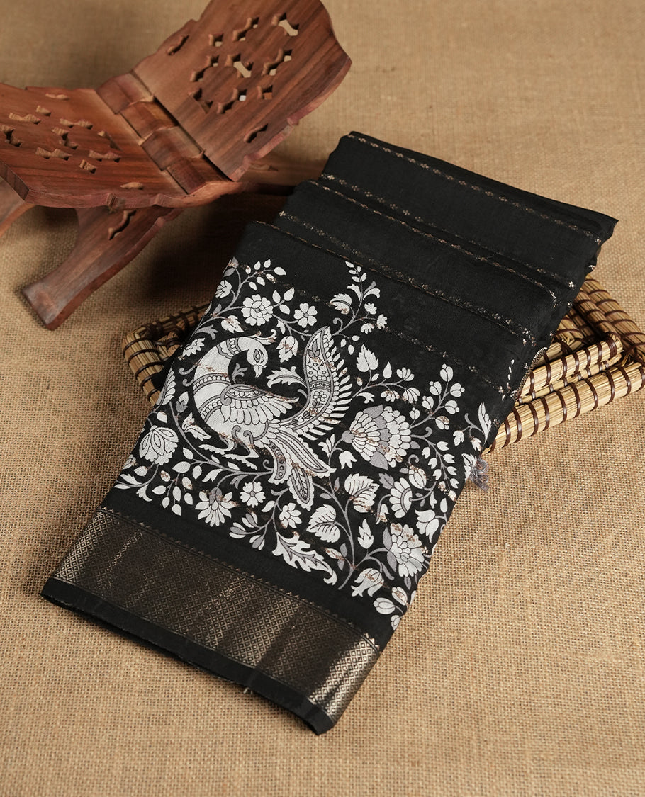 Black colour chanderi silk saree with gold zari strip pattern On body, compilmented by self colour border with antique zari pattern & white peacock & kodi print pattern and a matching blouse.