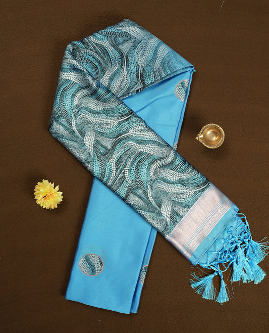 Sky blue semi silk saree featuring elegant circular motifs on the body, complemented by a striking pallu adorned with intricate wavy white thread patterns with golden border, and paired with a matching blouse