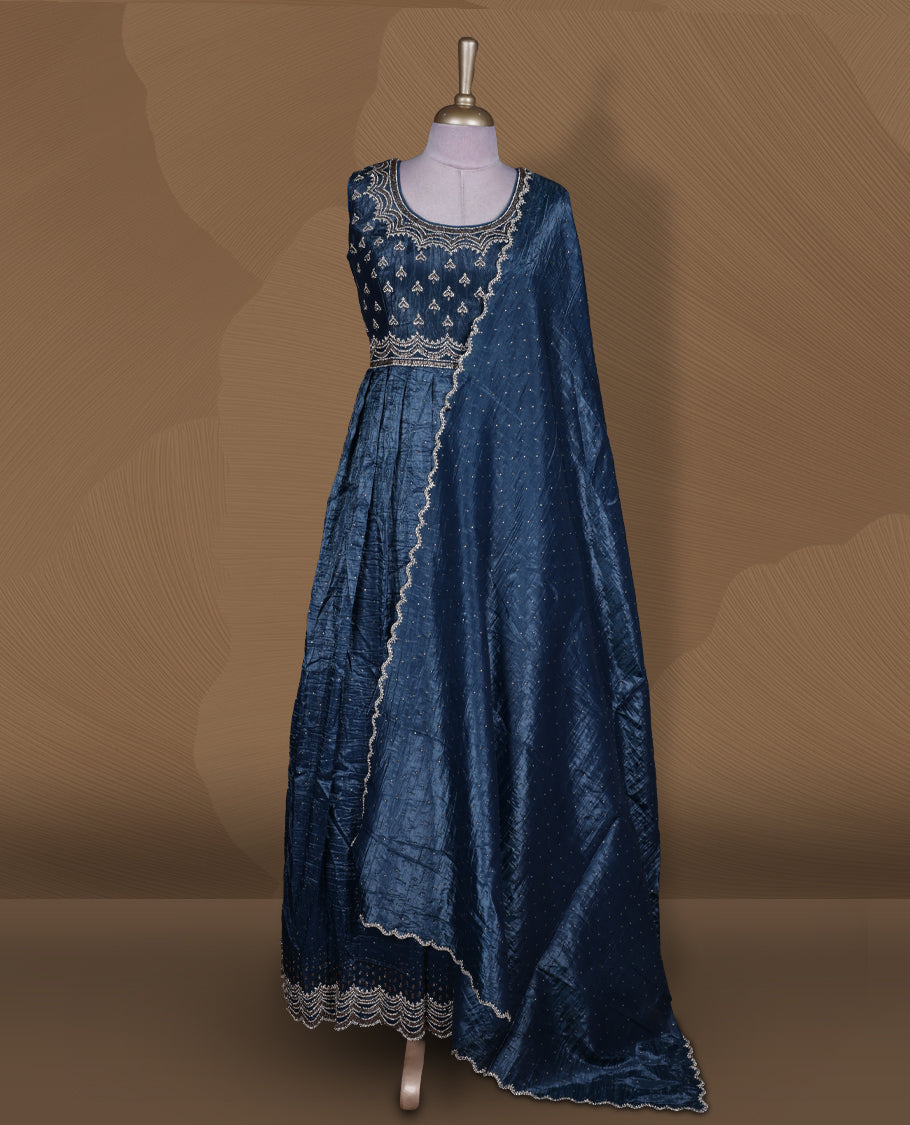 Midnight blue colour stitched gown set with sleeveless embroidered yoke, flared ankle‑length silhouette, and attached dupatta featuring dainty butti work and scalloped beaded edging.