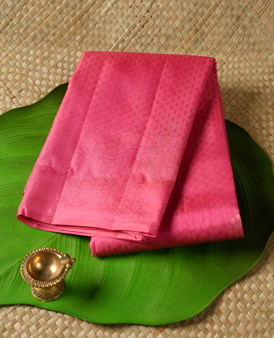 Pink colour Vasundhara silk saree adorned with all-over tiny motifs on the body, complemented by a self colour with self coloured with gold flower pattern on border and paired with a matching blouse piece.
