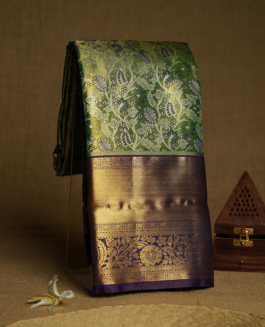 Light green colour and Antique silver Zari Tissue Brocade Saree features intricate floral Motifs on body and navy blue colour traditional border & pallu with floral  patterns, paired with matching blouse
