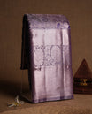 Lavender colour and Antique silver Zari Tissue Brocade Saree features intricate a navy blue coloured floral Motifs on body and A rose gold traditional border & pallu with floral patterns, paired with matching blouse