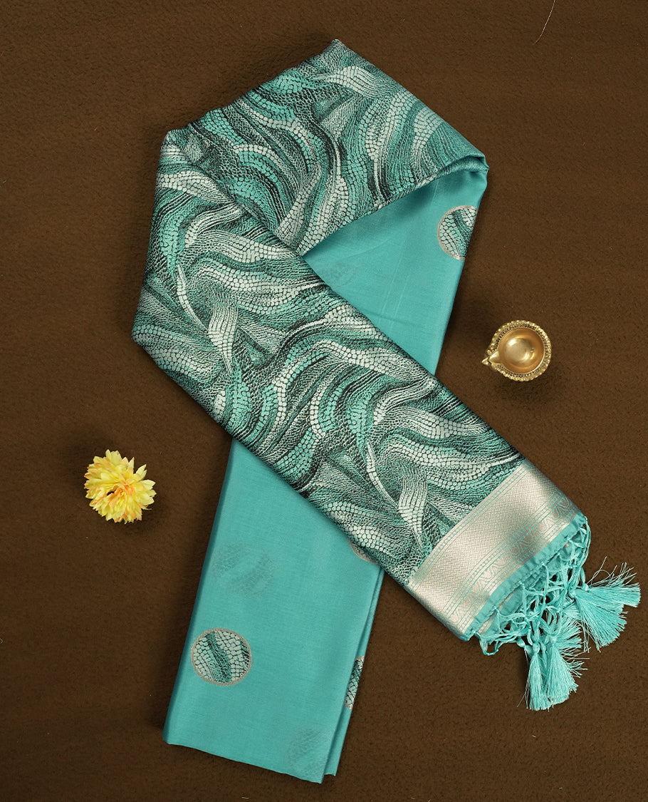 Aqua green semi silk saree featuring elegant circular motifs on the body, complemented by a striking pallu adorned with intricate wavy white and black thread patterns with golden border, and paired with a matching blouse