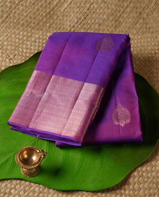 Indigo colour Vasundhara silk saree adorned with all-over gold motifs on the body, complemented by a self colour with gold tarditional border and paired with a matching blouse piece.