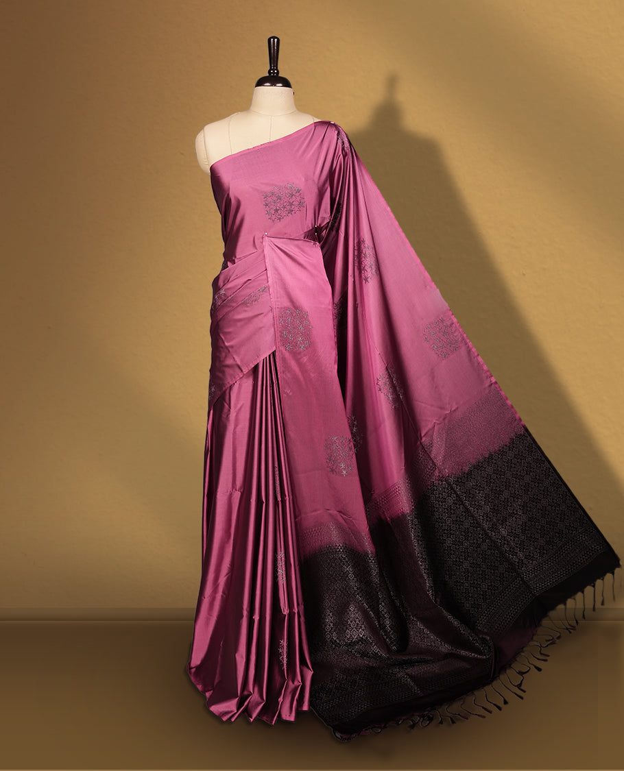 Dark mauve colour semi soft silk saree adorned with delicate woven floral motifs on the body, complemented by a rich contrast deep chocolate colour woven pallu with intricate detailing and tassel accents. Comes with a matching blouse piece