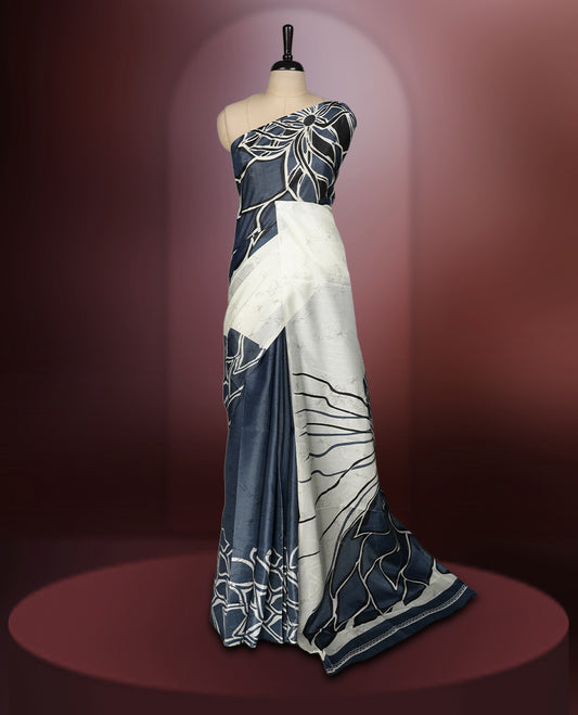 Grey and off white colour saree adorned with striking abstract floral designs, offering a perfect fusion of elegance and contemporary charm & paired with a matching blouse.