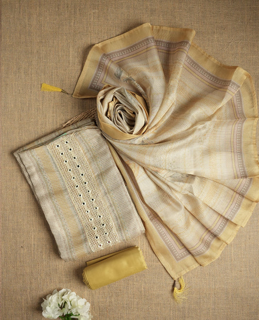 Pastel yellow and beige colour suit material with delicate woven mirror work patterns and subtle zari detailing & Includes a soft dupatta with a floral touch and plain matching bottom.