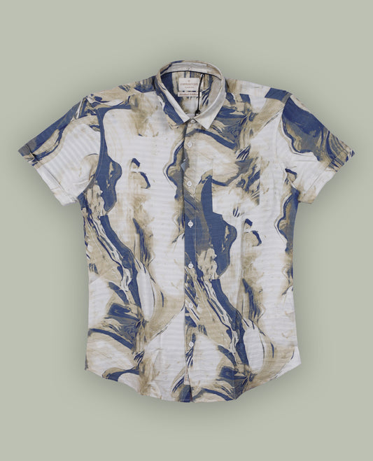 Off white colour shirt features a bold abstract print in blue and white tones, With short sleeves and a button-down front, its made from textured fabric, offering a stylish and modern look.