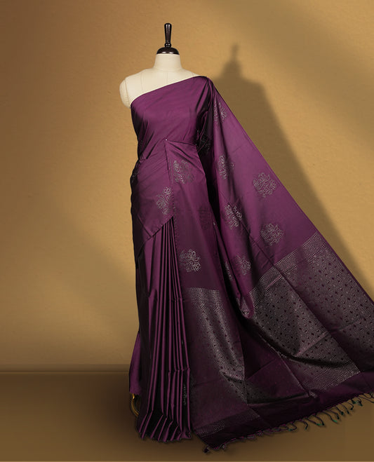 Grape colour semi soft silk saree, adorned with subtle self woven motifs on the body & The design is elevated with an elegant zari border and pallu, paired with a matching blouse.