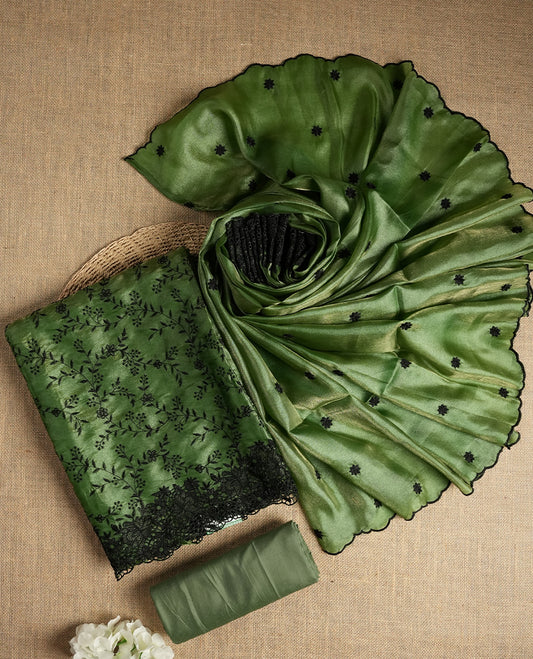 Rich Green colour dual shaded suit material with delicate black floral embroidery and lace border & Includes matching dupatta with embroidered motifs and plain bottom fabric.