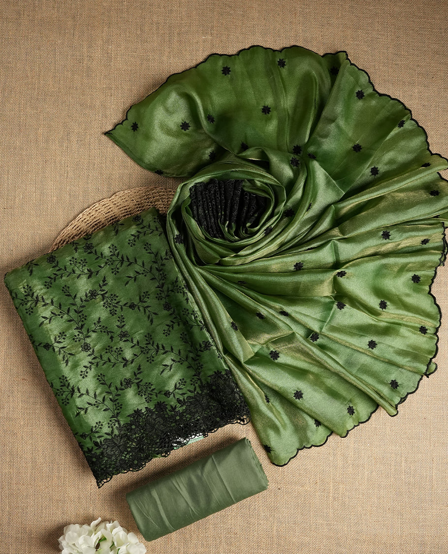 Rich Green colour dual shaded suit material with delicate black floral embroidery and lace border & Includes matching dupatta with embroidered motifs and plain bottom fabric.