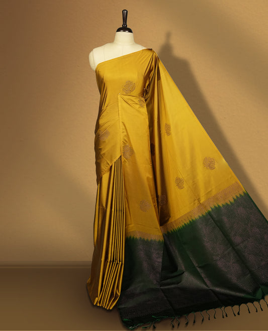 Deep mustard yellow colour semi soft silk saree, beautifully designed with woven leaf motifs & The look is enhanced by a rich contrast green pallu, paired with a matching blouse.