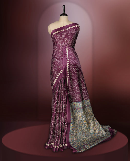 Dark grape colour saree adorned with intricate beige bandhani patterns and a contrasting pallu featuring exquisite beige floral motifs, perfectly paired with a matching blouse for a regal look.