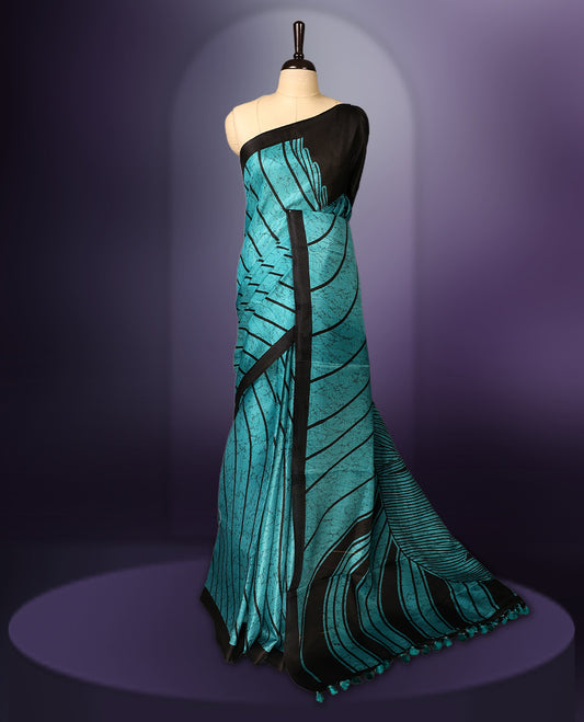 Elegant teal and black saree with abstract stripes and tassel detailed pallu & Perfect for festive and party occasions. Includes unstitched blouse piece. Style with minimal jewelry for a chic look.