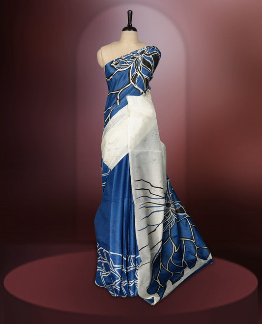 Blue and off white colour saree featuring bold floral patterns and contemporary artistry, bringing together tradition and modern style & paired with a matching blouse.