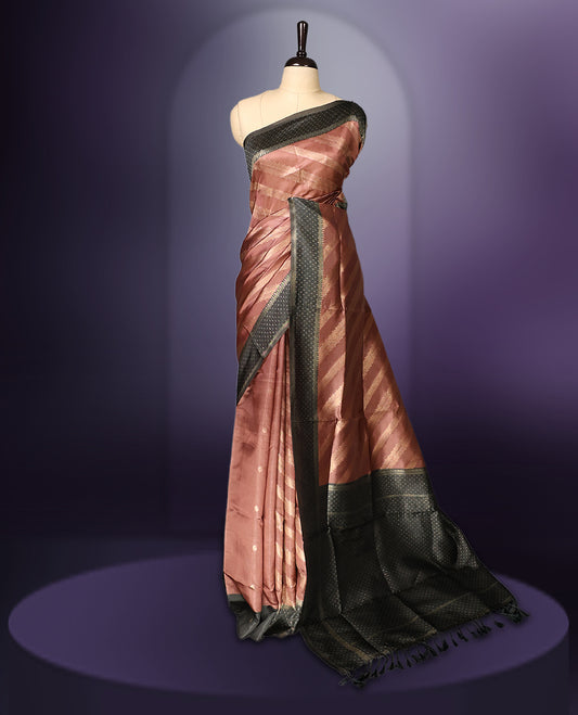 Golden Peach colour saree featuring subtle self striped woven patterns on the body, enhanced with a olive green geometric border, complemented by a rich zari pallu with tassels, and paired with a matching blouse for a traditional elegant look.