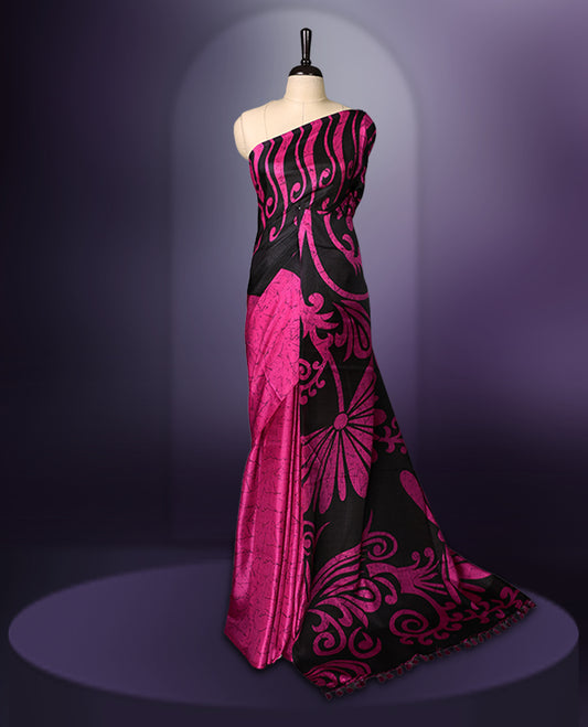 Black and Pink colour semi modal saree featuring bold floral and abstract motifs across the body, complemented by a striking patterned pallu, finished with tassel details and paired with a matching blouse.