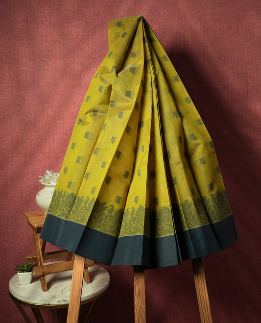 Lemon yellow colour silk cotton saree featuring elegant floral zari motifs on the body, complemented by a rich contrast dark plain border and pallu with traditional woven detailing & Comes with a matching blouse piece.