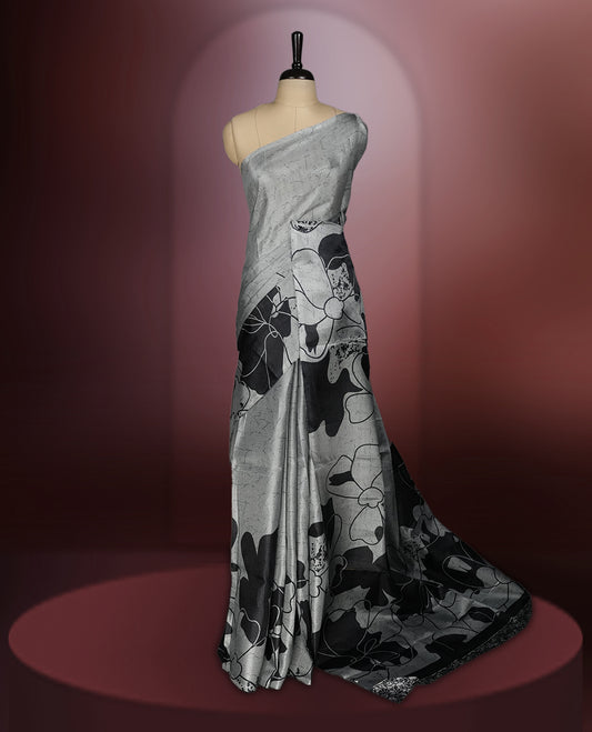 Grey colour saree with striking black floral patterns, merging modern minimalism with timeless charm & paired with a matching blouse.