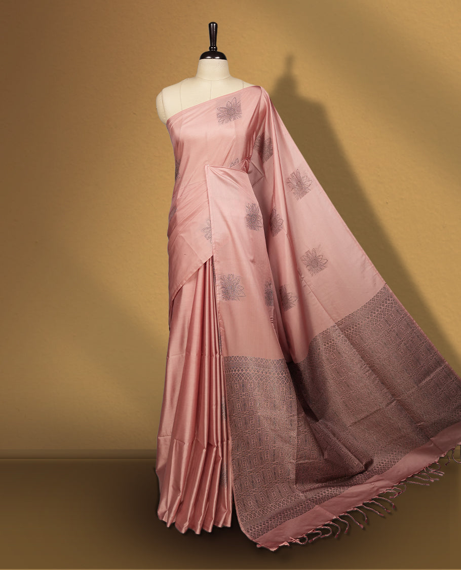Soft peach colour semi soft silk saree, adorned with subtle woven floral motifs on the body & The design is elevated with an elegant zari border and pallu with tassels, paired with a matching blouse.