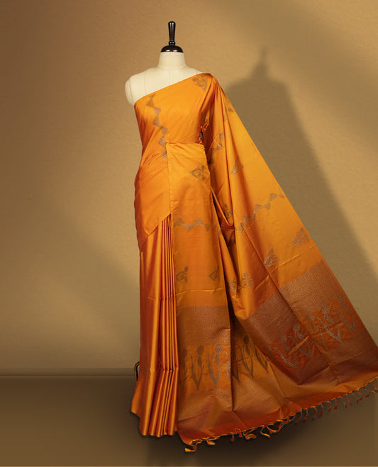Mustard yellow colour semi soft silk saree, adorned with subtle woven motifs on the body & The design is elevated with an elegant zari border and pallu, paired with a matching blouse.