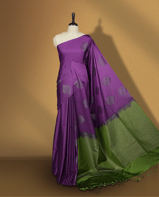 Purple colour semi soft silk saree, beautifully designed with self woven motifs & The look is enhanced by a rich contrast green border and pallu, paired with a matching blouse.