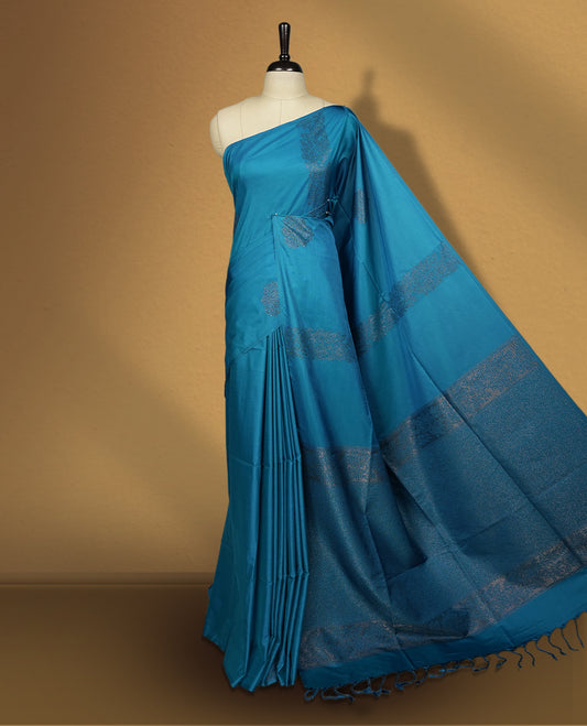Rich Blue colour semi soft silk saree, adorned with subtle self woven motifs on the body & The design is elevated with an elegant zari border and pallu with tassels, paired with a matching blouse.