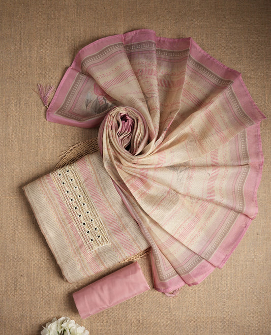 Pastel pink and beige colour suit material with delicate woven mirror work patterns and subtle zari detailing & Includes a soft dupatta with a floral touch and plain matching bottom.