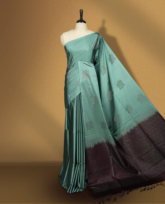 Turkish blue colour semi soft silk saree, beautifully designed with woven floral motifs & The look is enhanced by a rich contrast deep wine colour border and pallu with tassels, paired with a matching blouse.