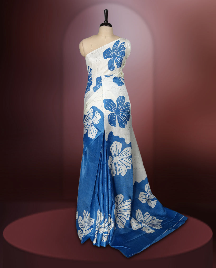 Sapphire blue colour semi khadi silk saree with off white floral motifs and subtle , exuding timeless elegance and modern charm & paired with a matching blouse.