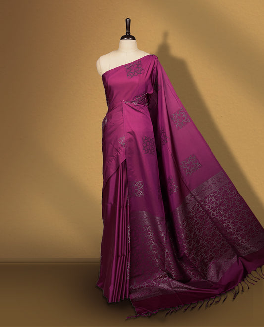 Wine colour semi soft silk saree, adorned with subtle self woven motifs on the body & The design is elevated with an elegant zari border and pallu, paired with a matching blouse.