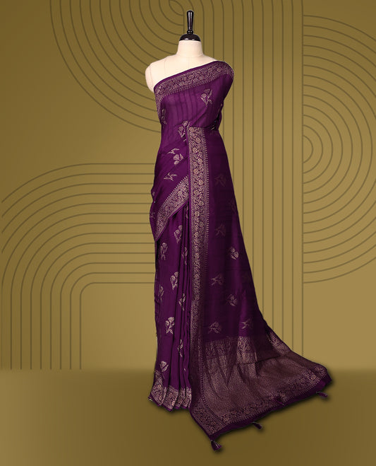 Wine colour semi Banaras tussar saree adorned with golden floral motifs along the border and scattered across the body, finished with a rich golden zari pallu, paired with a matching blouse.