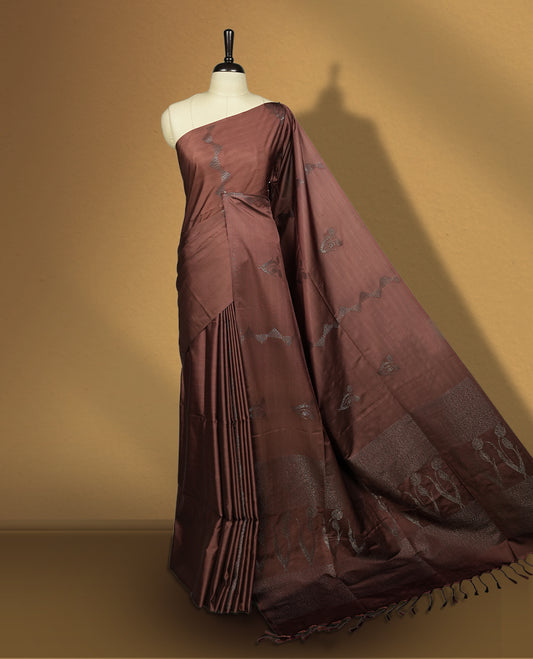 Brown colour semi soft silk saree with delicate woven motifs on the body, complemented by a beautifully designed pallu with tassels & Paired with a matching blouse piece, this drape exudes timeless elegance.