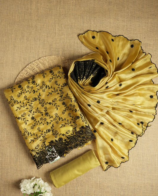 Elegant mustard yellow colour dual shaded suit material with delicate black floral embroidery and lace border & Includes matching dupatta with embroidered motifs and plain bottom fabric.