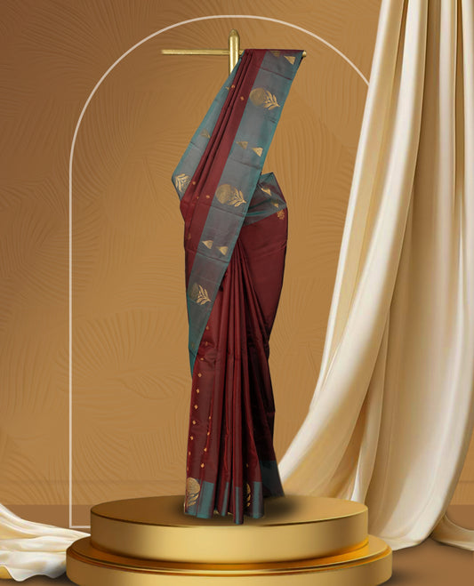 Dark maroon colour soft silk saree with a stunning maroon and teal green colour double shaded border, rich golden zari motifs, and a paired matching blouse.