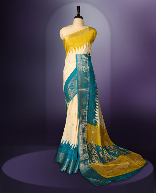 Off white and yellow colour saree adorned with subtle woven motifs across the body, enhanced by a rich teal and silver zari border, featuring a vibrant artistic pallu with intricate traditional patterns, paired with a matching blouse.