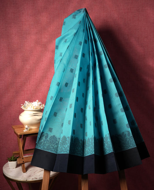 Sky blue colour silk cotton saree featuring elegant floral zari motifs on the body, complemented by a rich contrast dark plain border and pallu with traditional woven detailing & Comes with a matching blouse piece.