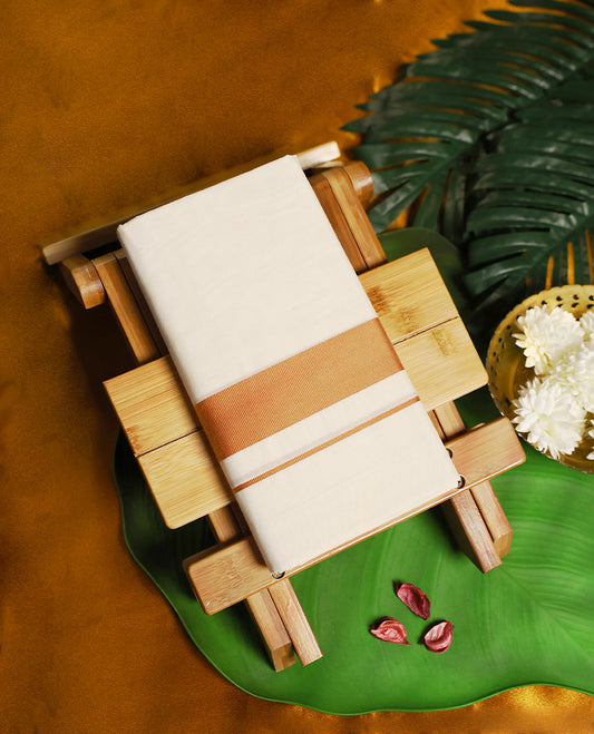 Traditional off white colour pure cotton dhoti featuring a classic copper zari border, blending tradition with understated elegance, making it an ideal choice for weddings, festive occasions, and temple rituals.
