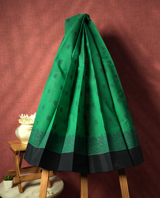 Emerald green colour silk cotton saree featuring subtle woven motifs throughout the body, enhanced by a striking grey contrast border and an intricately designed pallu with floral patterns &  Comes with a matching blouse piece.