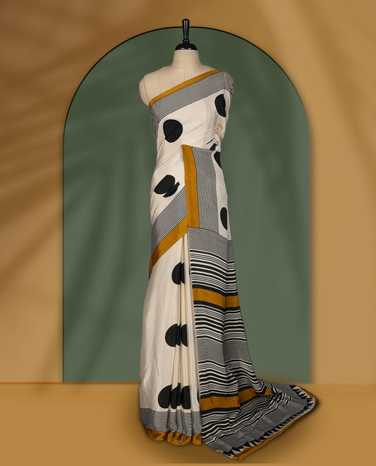 Cream colour saree with bold black polka dots, fine striped design, and mustard yellow borders & Paired with a matching blouse.