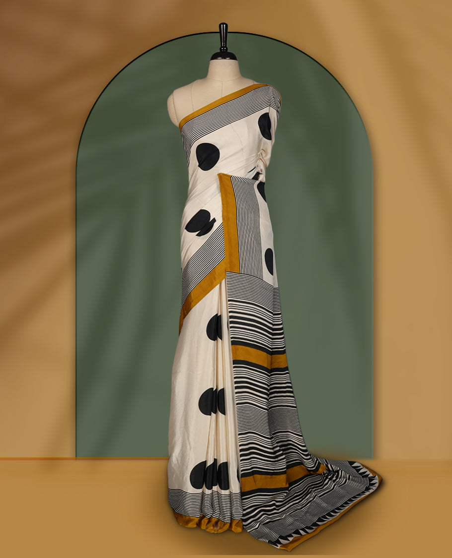 Cream colour saree with bold black polka dots, fine striped design, and mustard yellow borders & Paired with a matching blouse.