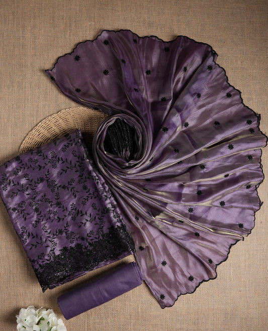 Rich lavender colour dual shaded suit material with delicate black floral embroidery and lace border & Includes matching dupatta with embroidered motifs and plain bottom fabric.