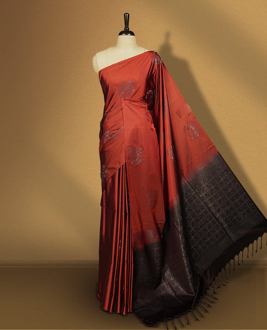 Deep copper colour semi soft silk saree adorned with delicate woven motifs on the body & Enhanced with a striking dark brown contrast zari border and elegant pallu, paired with a matching blouse.
