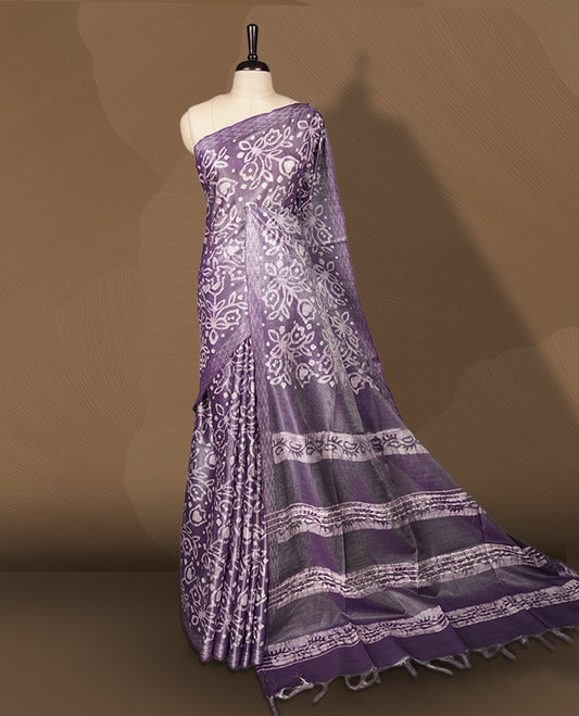 Lavender semi jute tissue saree adorned with elegant white floral motifs all over the body, paired with a beautifully woven pallu and patterned borders & Comes with a matching blouse piece.