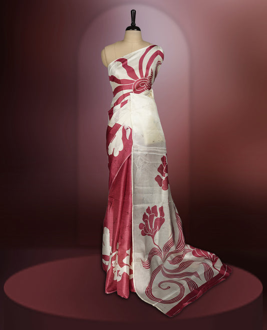 Cream and maroon colour saree with bold abstract floral patterns and a striking pallu design, blending modern artistry with traditional charm, paired with a matching blouse.