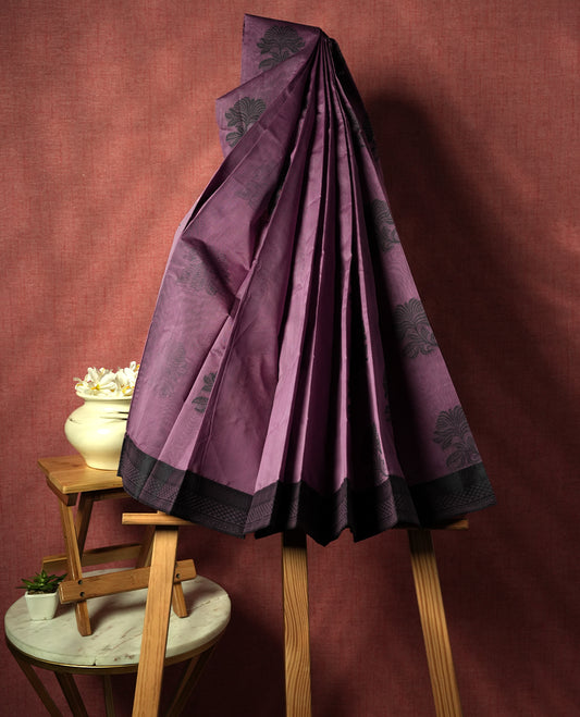Pastel purple colour silk cotton saree featuring elegant floral zari motifs on the body, complemented by a rich contrast dark border and pallu with traditional woven detailing & Comes with a matching blouse piece.