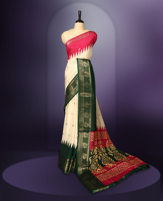 Off white colour saree with subtle golden buttas, highlighted by a vibrant pink pallu and rich green zari border adorned with intricate motifs, paired with a matching blouse.