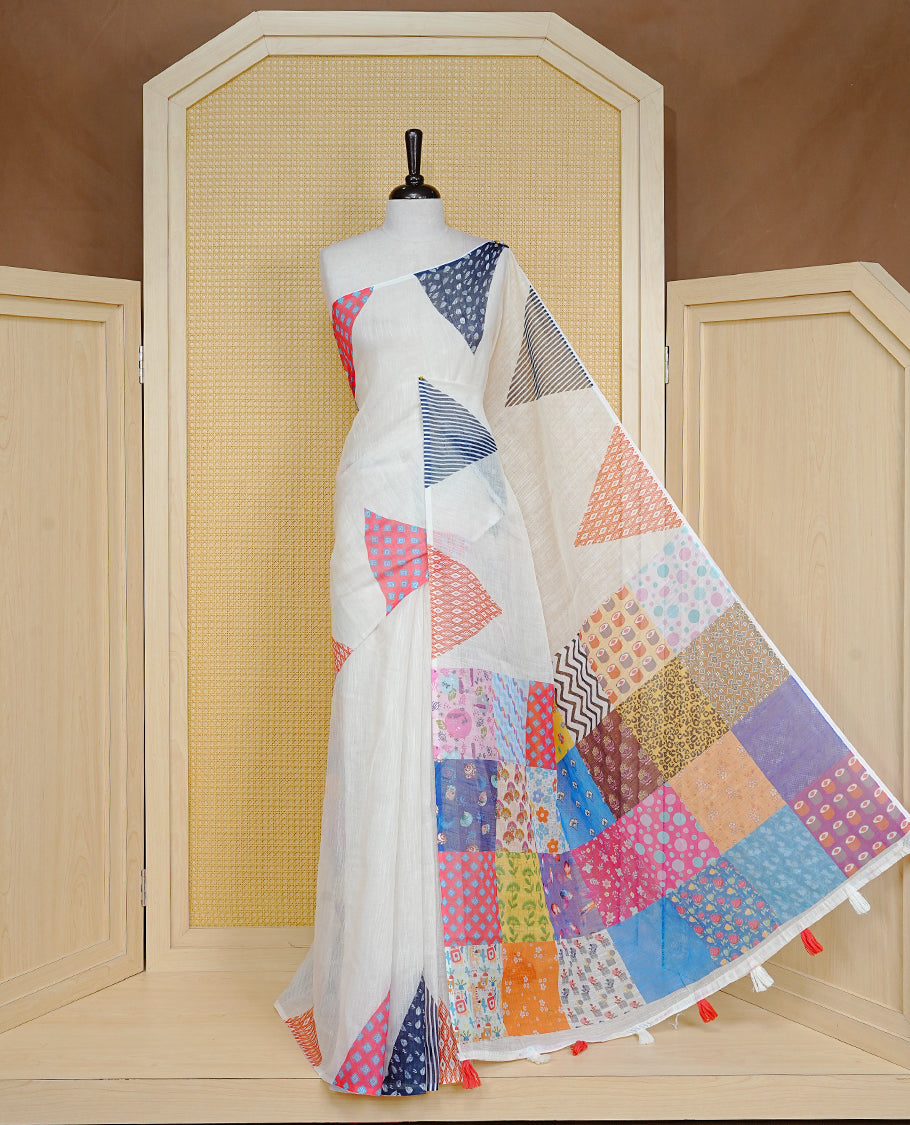 Off White colour Semi Linen Saree Featuring Elegant Plain body with Colourful Triangle Border, Unique Tassel Detailing For Festive Vibe, Patch worked Blouse piece.