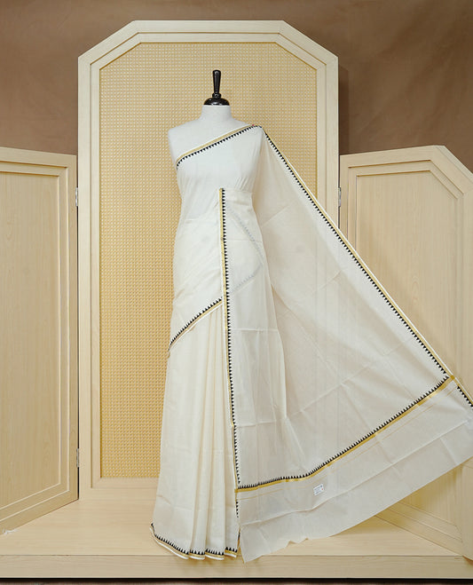 Cream Colour Cotton Kerala Saree Featuring A Gold Zari Border And Black Temple Edging, Paired With A Matching Blouse Piece